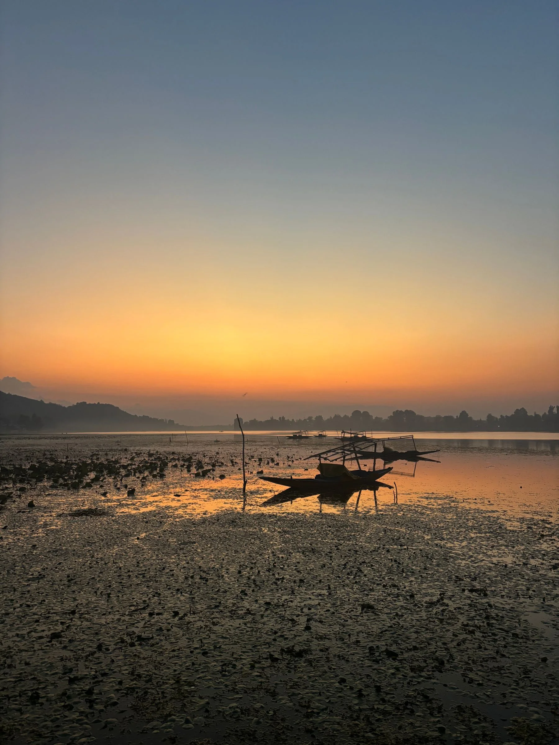 Small boat on still water at sunrise