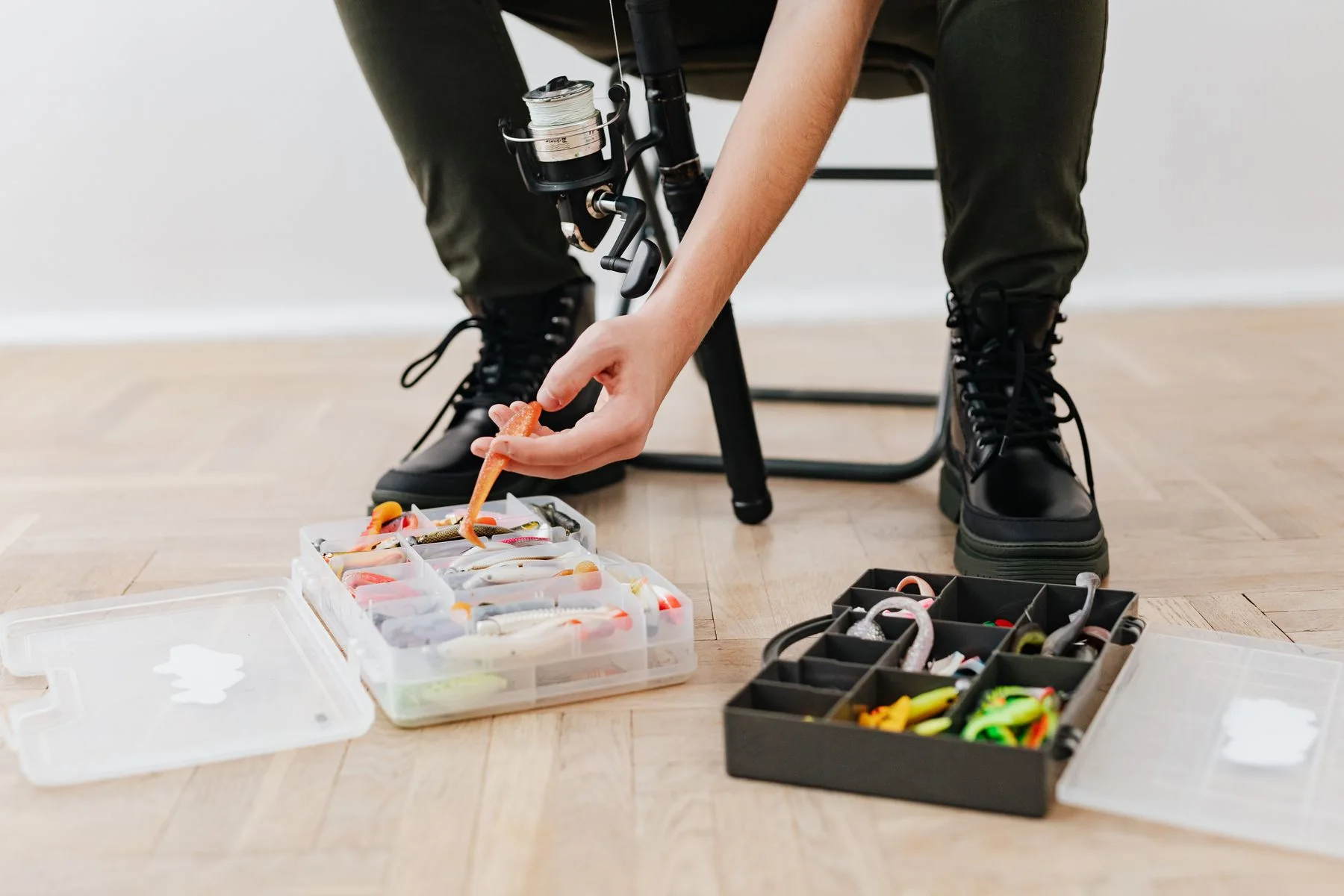 Hands arranging lures in a tackle box
